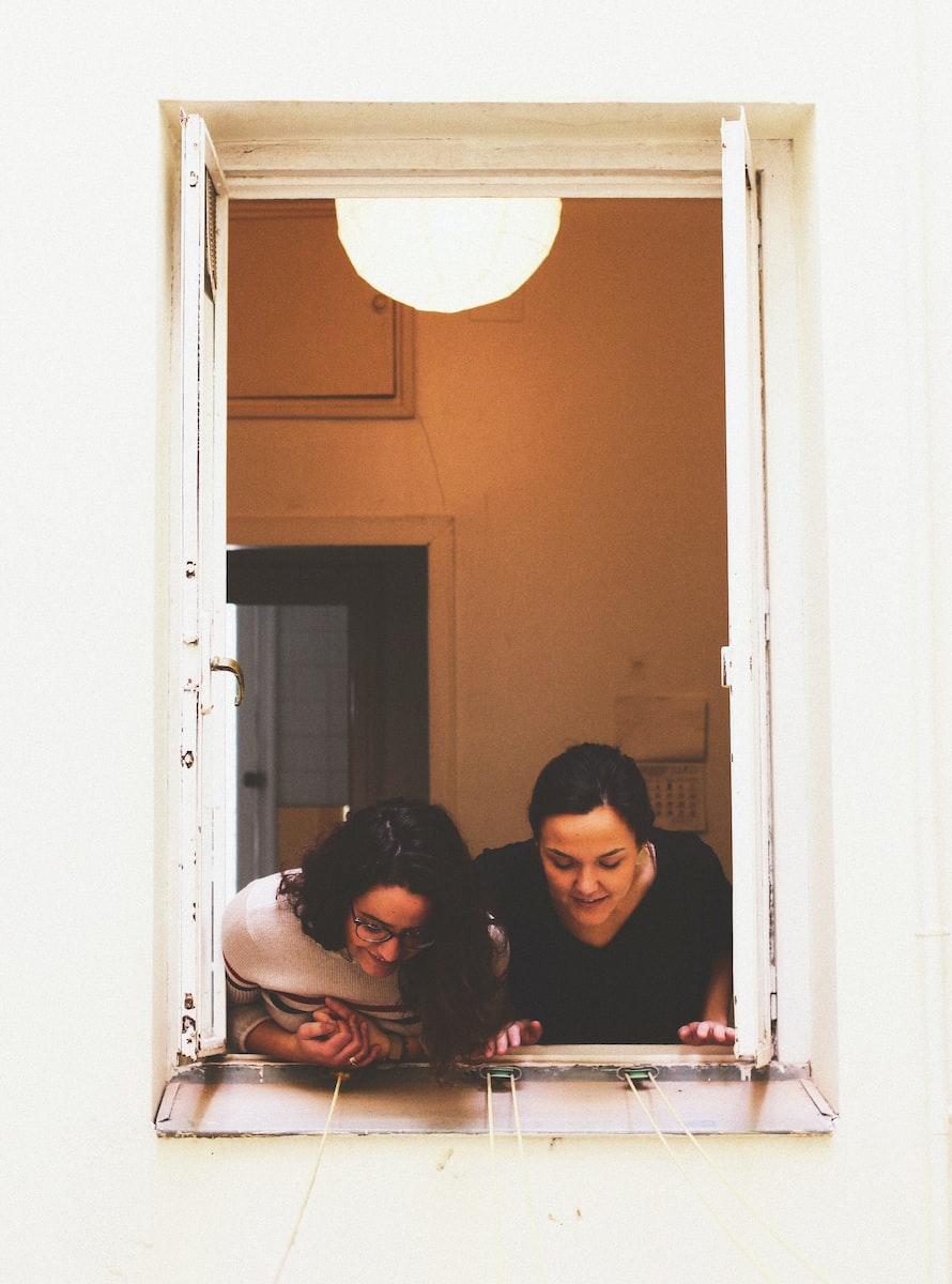 deux femmes regardant par la fenêtre