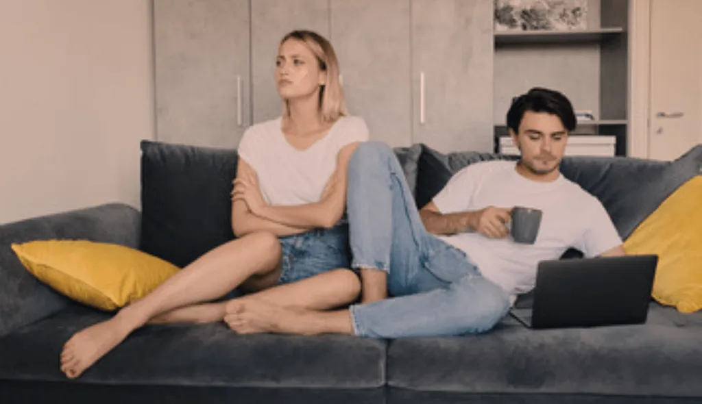 Couple sitting on the sofa facing in the opposite direction to each other