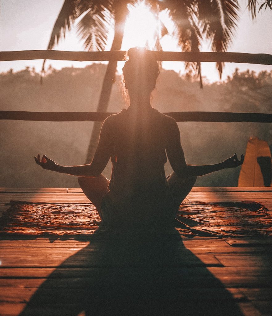 femme faisant du yoga et de la méditation sur un parquet brun