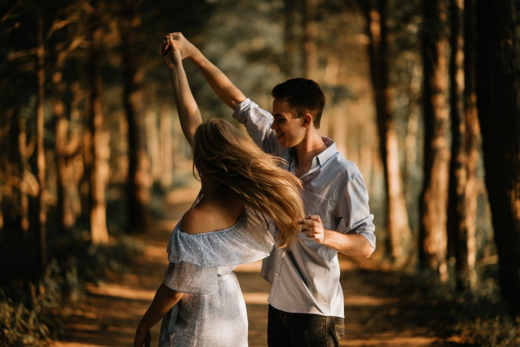homme et femme dansant au centre des arbres