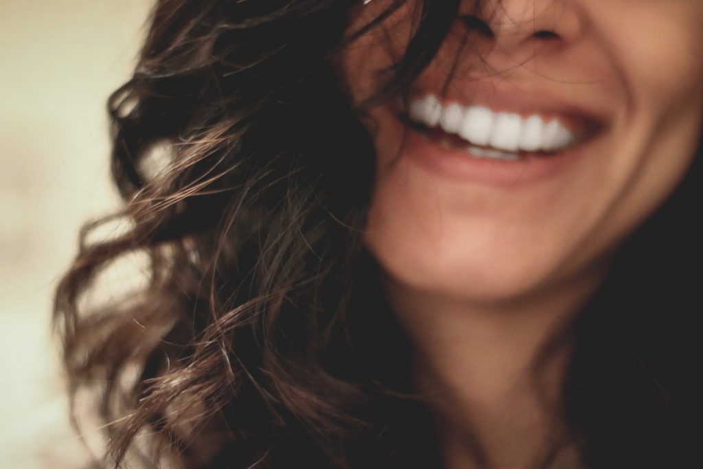 femme aux cheveux longs et noirs souriant photographie en gros plan