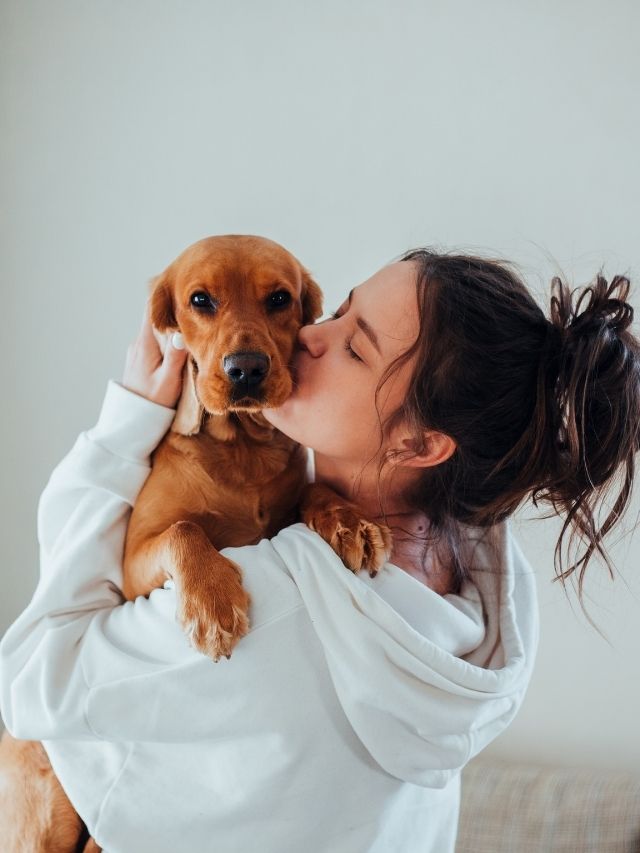 femme qui embrasse un chien