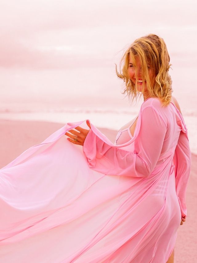 femme à la plage vêtue de rose